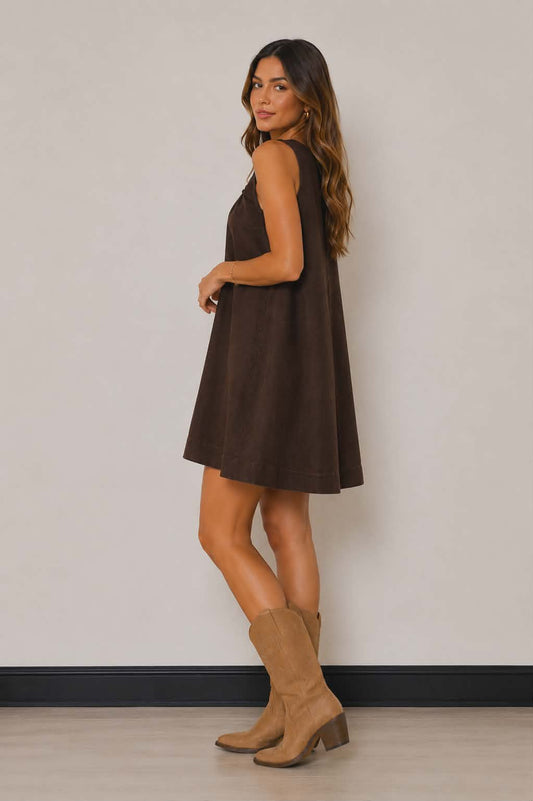 Dark chocolate mini dress featuring a loose smock fit, wide shoulder straps and lightweight denim-style fabric. A versatile country style dress perfect for concerts, markets and everyday wear