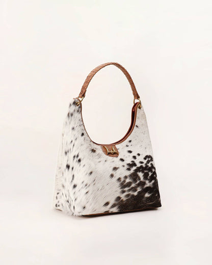 Hobo bag with cow print pattern on a light background