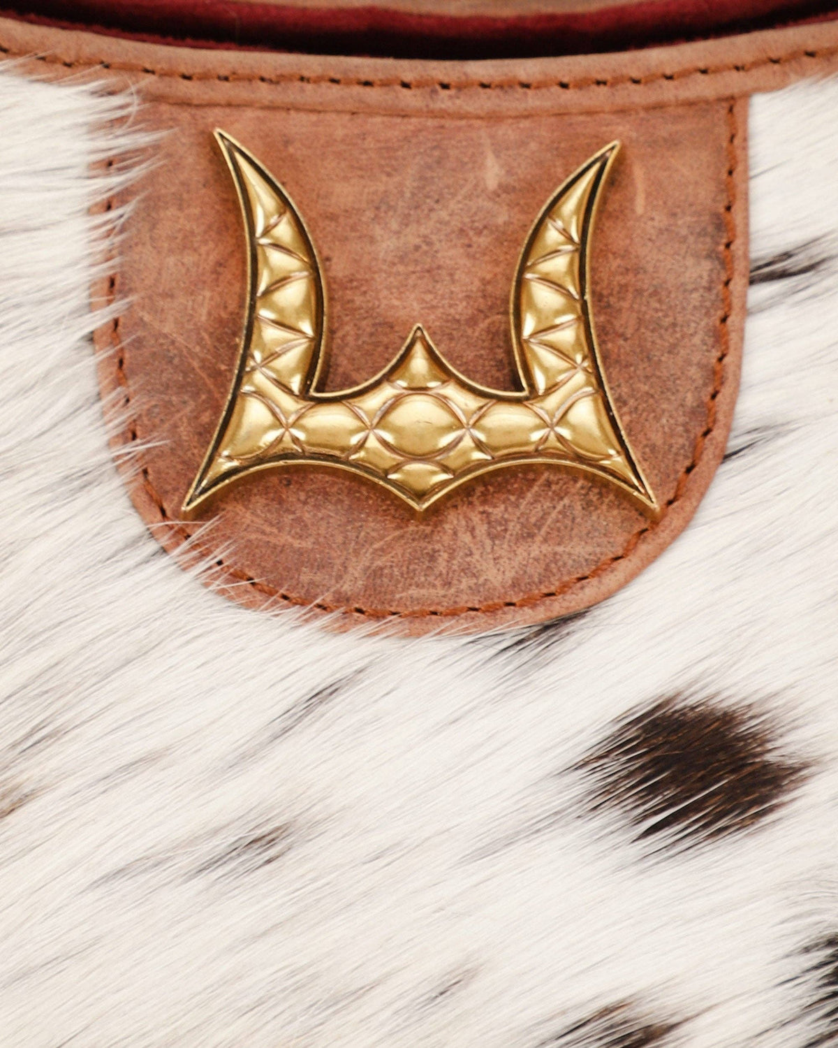 Gold emblem on a leather patch with fur background