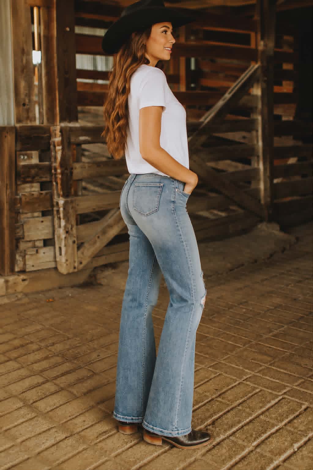 Women's light blue flare jeans featuring stretch denim, a vintage wash and subtle distressed accents for everyday western style.