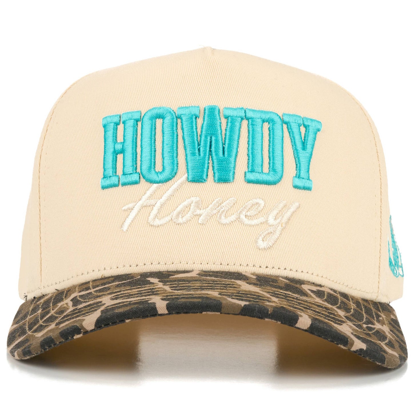 Front view of full-cotton trucker cap featuring turquoise embroidered “Howdy” and off-white embroidered “Honey” lettering across the cream crown, a black and white cow print curved brim, and playful western-inspired country styling.