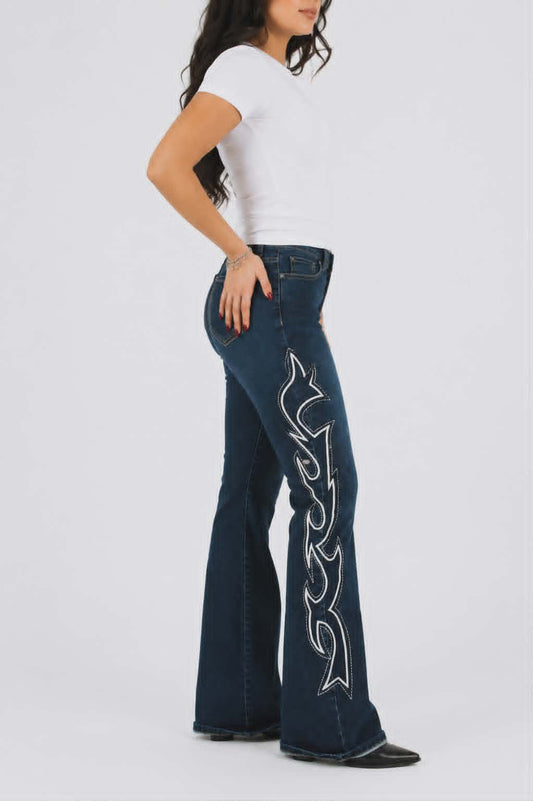 Model wearing dark wash western flare jeans with white contrast flame embroidery and white fittted tee on white background