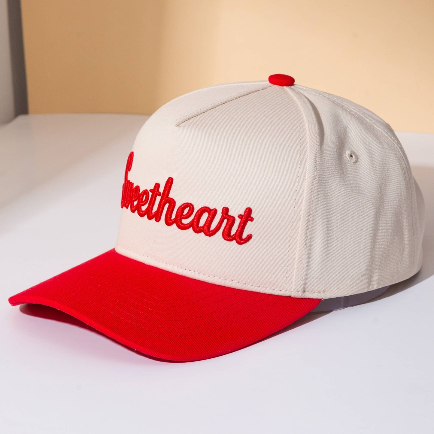 Cap with 'sweetheart' text on a beige background