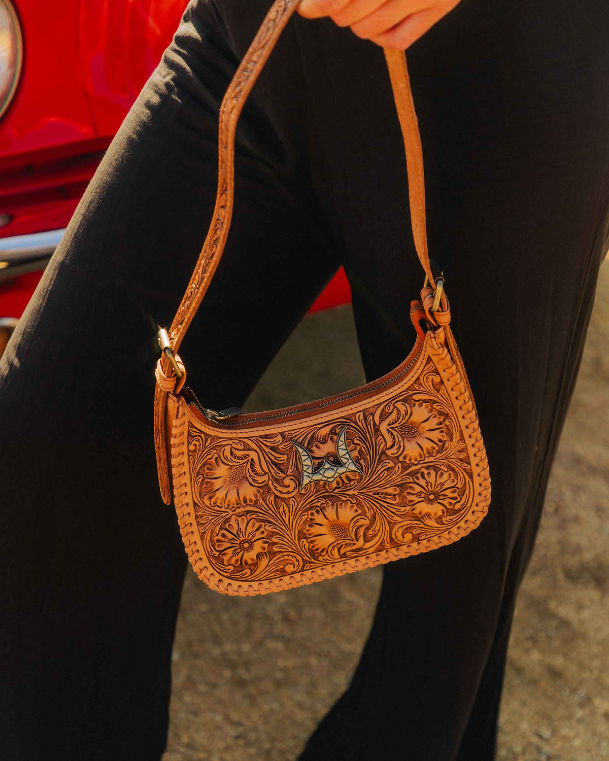 Genuine leather western shoulder bag with floral hand tooling, whipstitch edging and decorative metal hardware