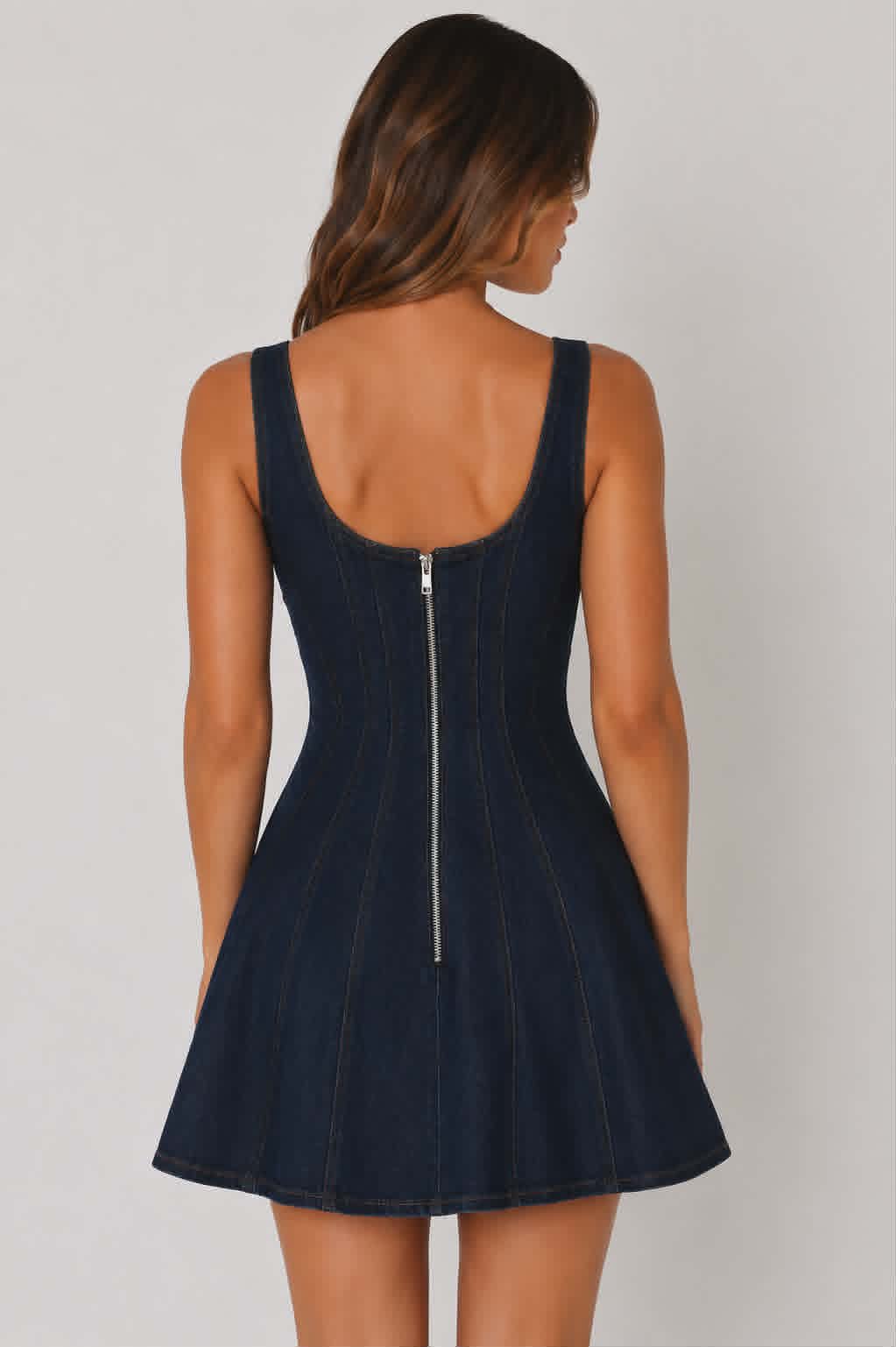 Fitted dark indigo denim dress with a flared mini skirt, wide shoulder straps and contour seam details. A versatile country style denim dress for festivals, nights out and everyday western styling