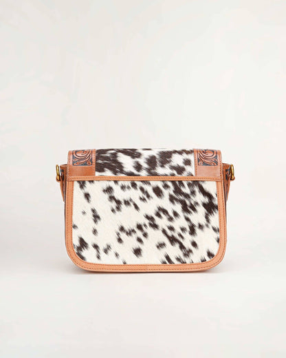 Crossbody bag with cow print pattern on a white background
