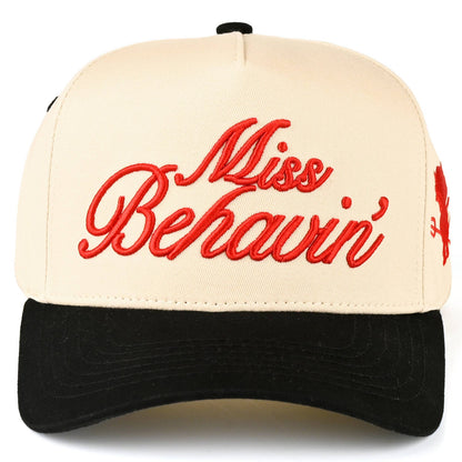 Cream and black trucker cap featuring red embroidered "Miss Behavin'" script