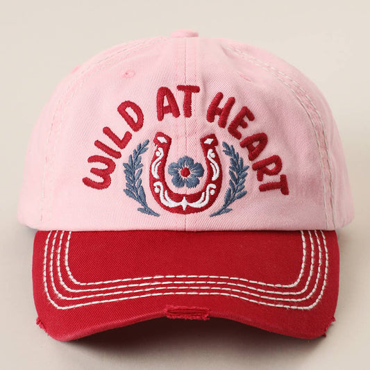 Pink and red vintage western cap with embroidered "Wild at Heart" horseshoe design