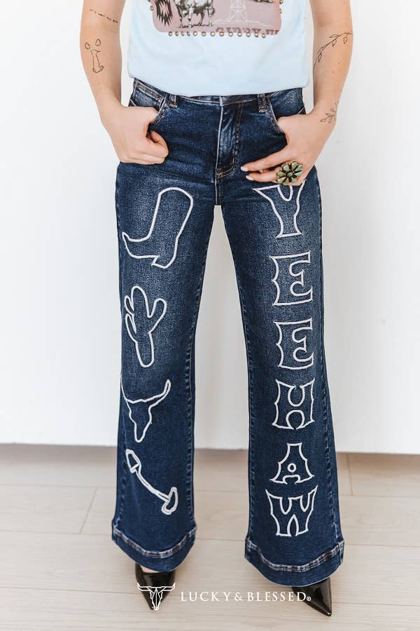 High waisted western wide leg denim jeans styled with a western graphic tee and black cowboy boots.