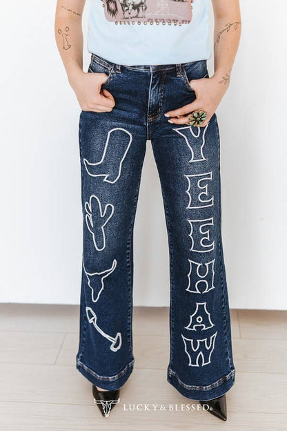 High waisted western wide leg denim jeans styled with a western graphic tee and black cowboy boots.