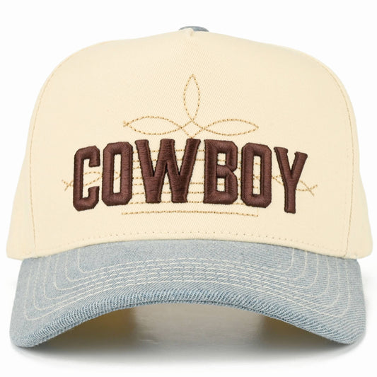 Front view of cream full cotton trucker cap featuring a light denim curved brim, chocolate brown embroidered Cowboy lettering, gold western boot stitch detail, and matching light denim embroidered air holes for a rustic country finishs