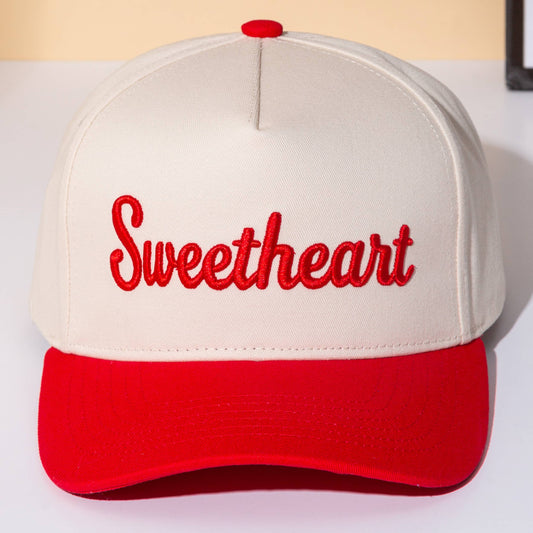Front view of baseball-style trucker cap featuring a cream crown, bold red embroidered “Sweetheart” lettering, matching red curved brim, and playful vintage-inspired western casual styling.