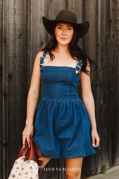 Women's denim buckle strap mini romper styled with a black cowboy hat