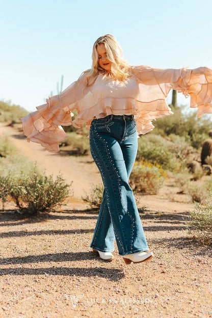 Dark wash country style jeans paired with cowboy boots and a flowy blouse