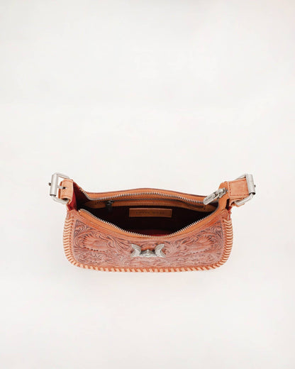 A peach-colored tooled leather shoulder bag shown open against a plain white background, displaying its interior zipper and western-style tooling details.