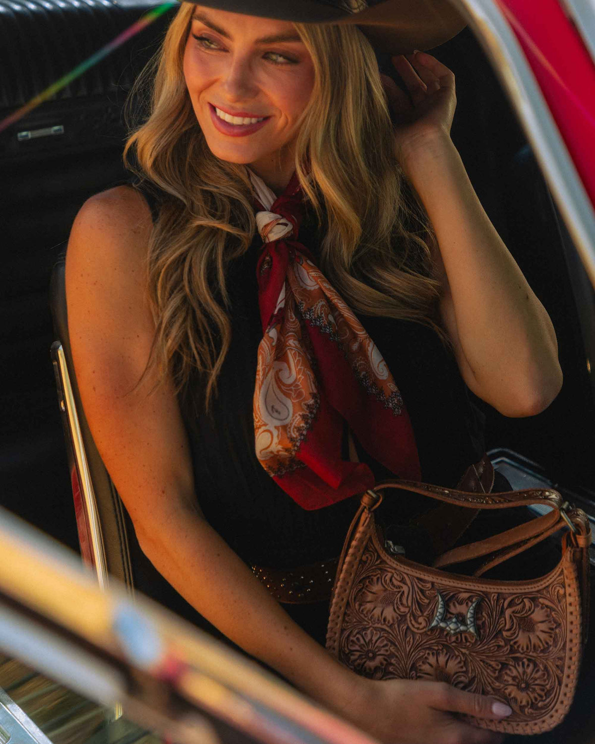 Dannia brown leather handbag featuring curved silhouette, zip closure and detailed shoulder strap