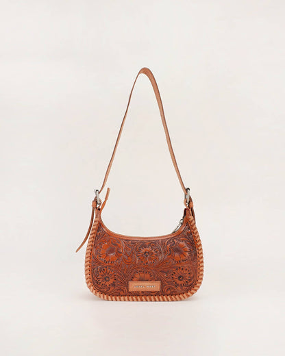 A brown tooled leather shoulder bag with floral embossing, a braided trim, and a long shoulder strap, shown against a plain off-white background.