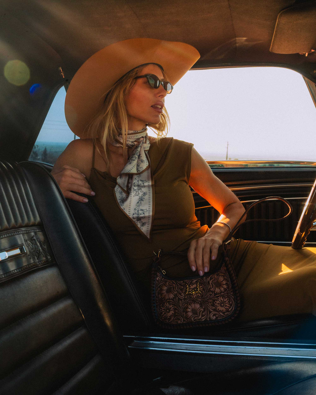 Western cowgirl shoulder bag featuring curved silhouette, zip closure and decorative stitching
