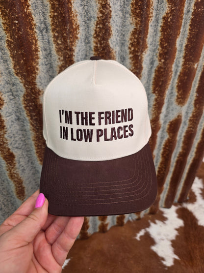 Western trucker hat with cream crown, brown curved brim and bold country music statement embroidery