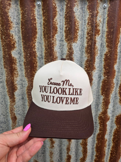 Country-style trucker cap in cream and brown with bold western typography and adjustable snapbac fit